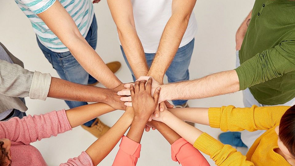 group of international people with hands together Hände zusammen