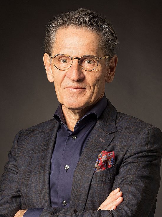 Ein Portraitfoto von Alexander Grob vor einem dunklen Hintergrund.