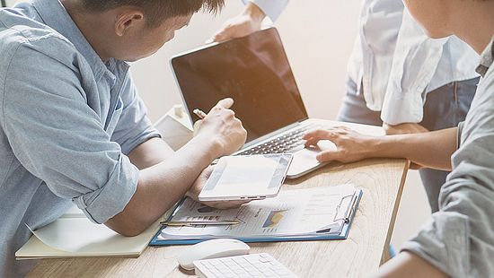 Two people working on the laptop